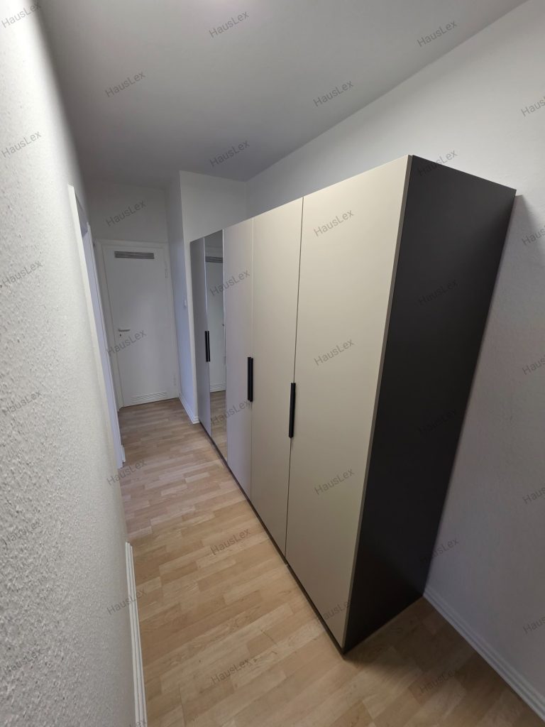 Seitenansicht des fertig montierten 5-türigen IKEA PAX Schranks. 5-türiger IKEA PAX Kleiderschrank mit Spiegeltür – fachgerecht montiert.